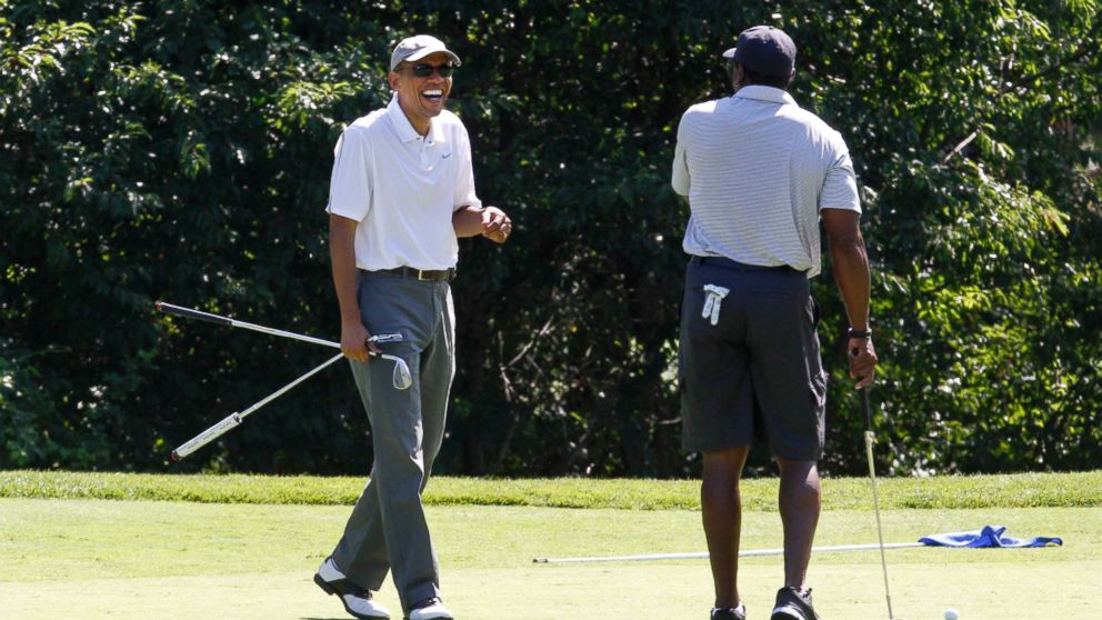 PHOTO: President Barack Obama laughs while golfing with former NFL player Ahmad Rashad at Farm Neck Golf Club in Oak Bluffs, Mass.,  on the island of Martha's Vineyard, Aug. 9, 2014. 