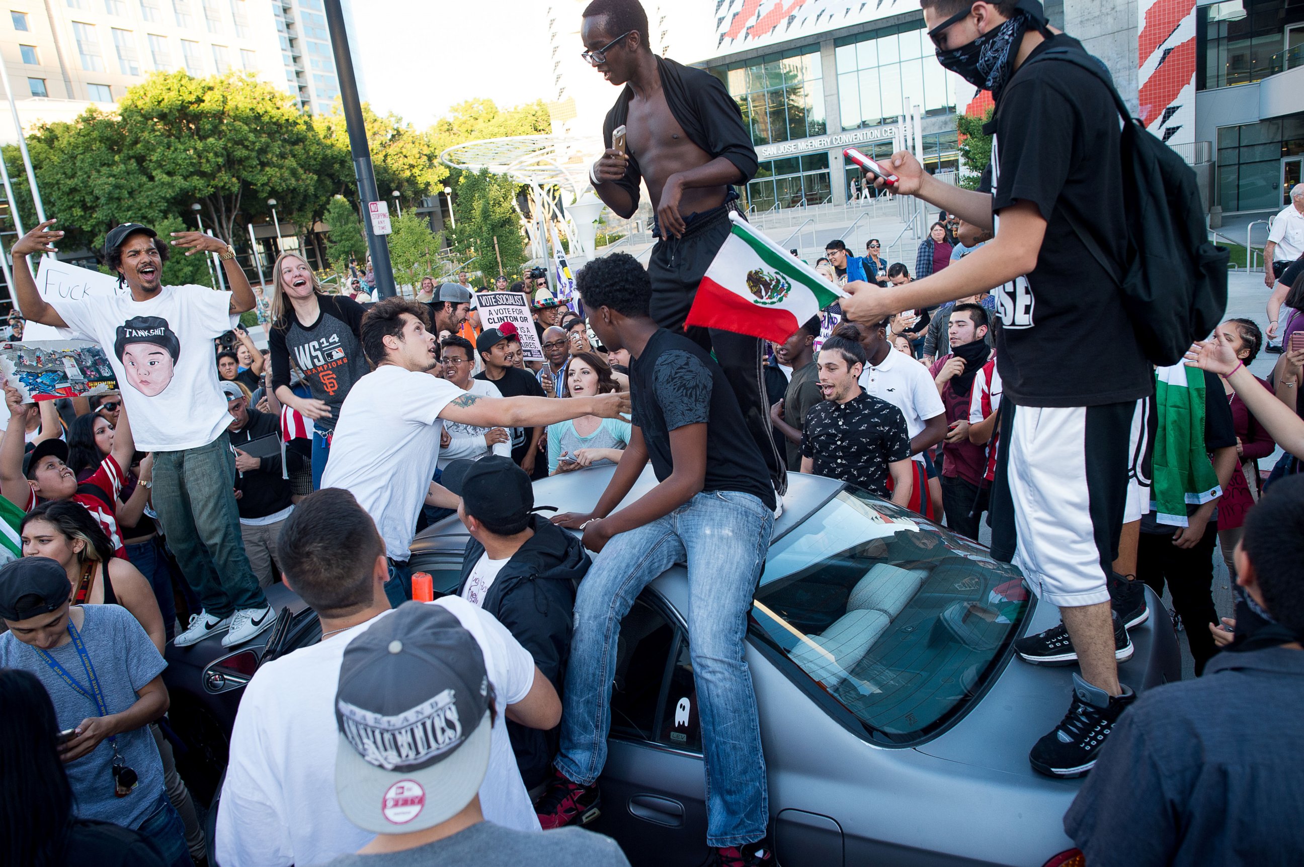 PHOTO: Protesters against GOP presidential candidate Donald Trump climb on a car outside a Trump campaign rally on Thursday, June 2, 2016, in San Jose, Calif. 