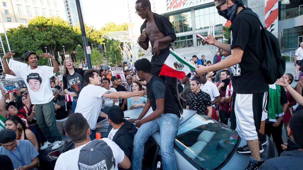 PHOTO: Protesters against GOP presidential candidate Donald Trump climb on a car outside a Trump campaign rally on Thursday, June 2, 2016, in San Jose, Calif. 