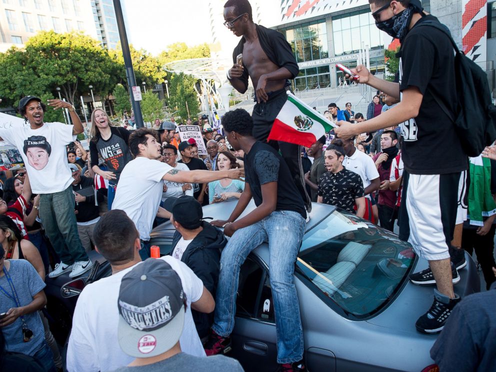 PHOTO: Protesters against GOP presidential candidate Donald Trump climb on a car outside a Trump campaign rally on Thursday, June 2, 2016, in San Jose, Calif.
