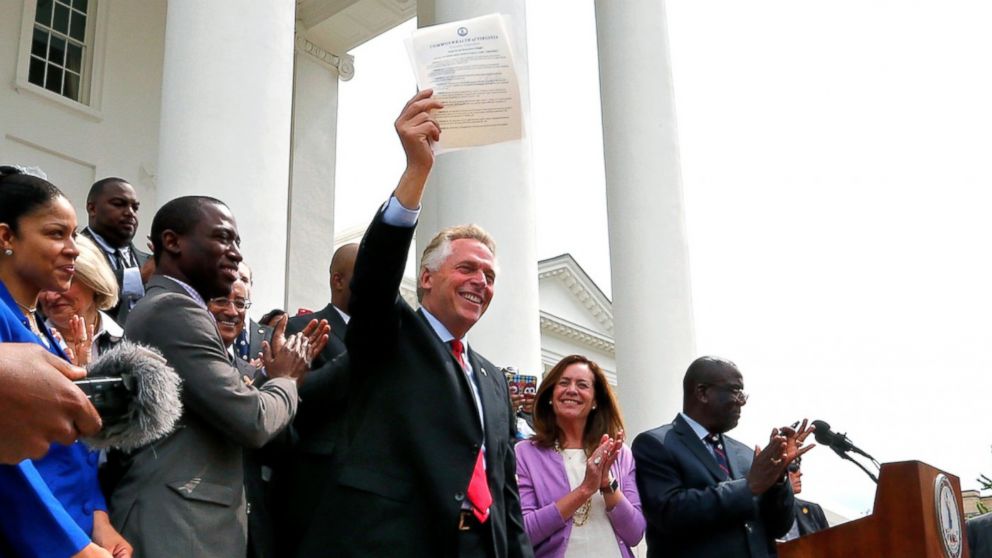 Terry McAuliffe holds up the order he signed to restore rights to felons in Virginia at the Capitol in Richmond, Virginia, April 22, 2016. 