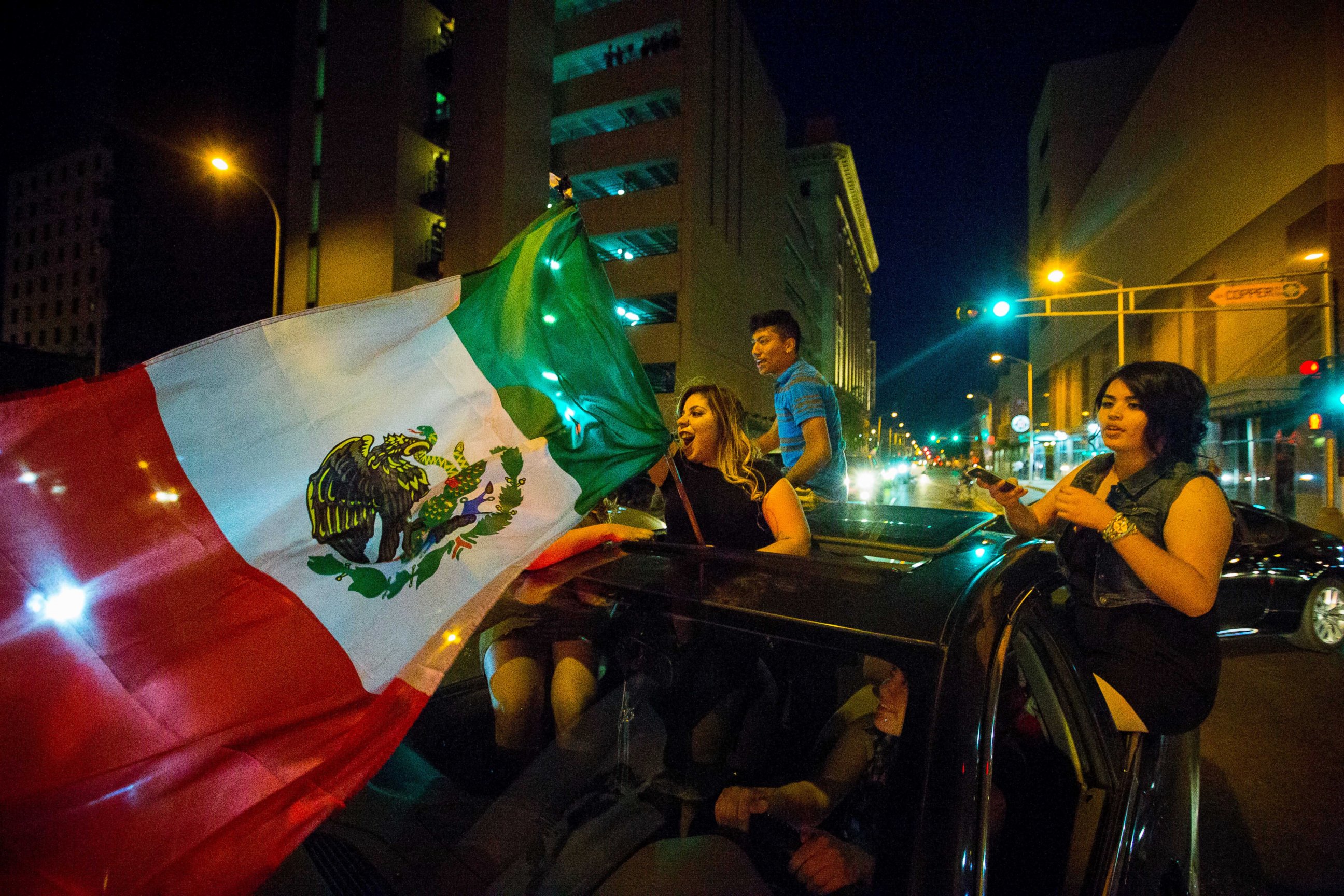 PHOTO: A woman waves the Mexican flag while driving past the Albuquerque Convention Center after a rally by Republican presidential candidate Donald Trump, May 24, 2016, in Albuquerque, N.M.