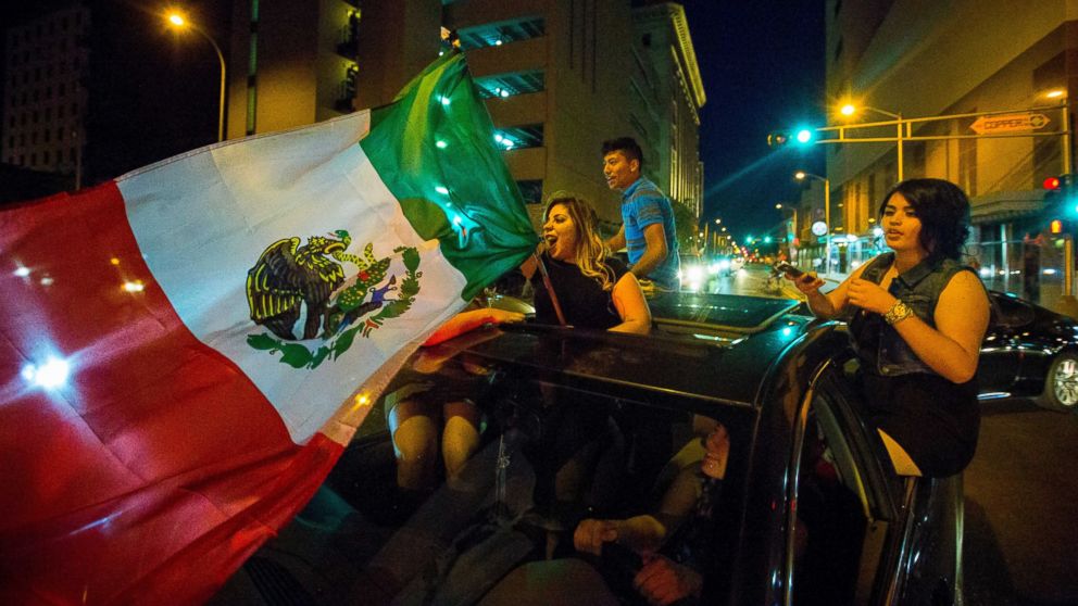 PHOTO: A woman waves the Mexican flag while driving past the Albuquerque Convention Center after a rally by Republican presidential candidate Donald Trump, May 24, 2016, in Albuquerque, N.M.
