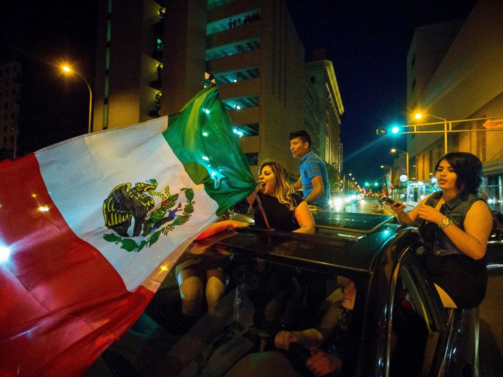 PHOTO: A woman waves the Mexican flag while driving past the Albuquerque Convention Center after a rally by Republican presidential candidate Donald Trump, May 24, 2016, in Albuquerque, N.M.
