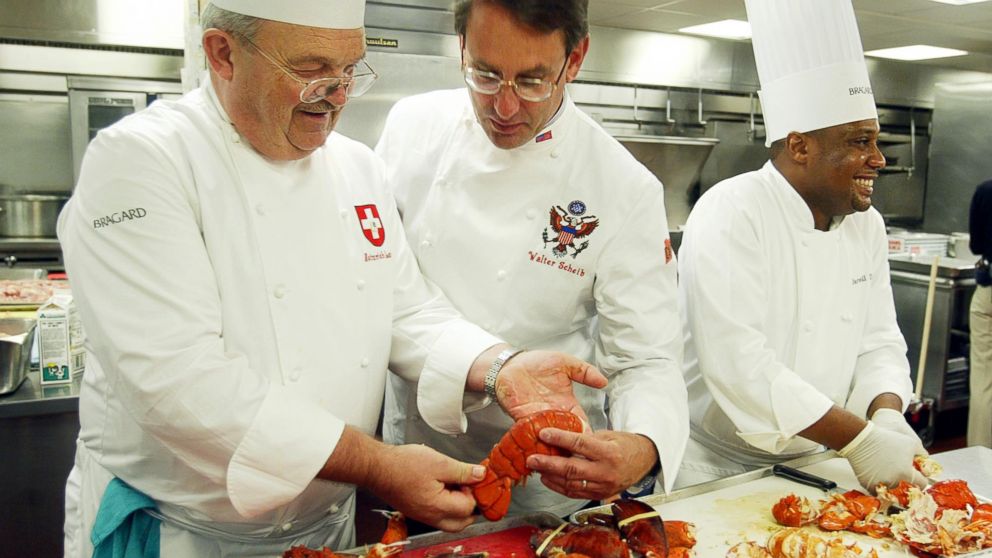 PHOTO: Heinrich Lauber, left, Chef in Charge of the Official Receptions of Switzerland, shows former White House Chef Walter Scheib, center, in this file photo, cooked lobsters, at the Willard InterContinental Washington,  July 26, 2004. 