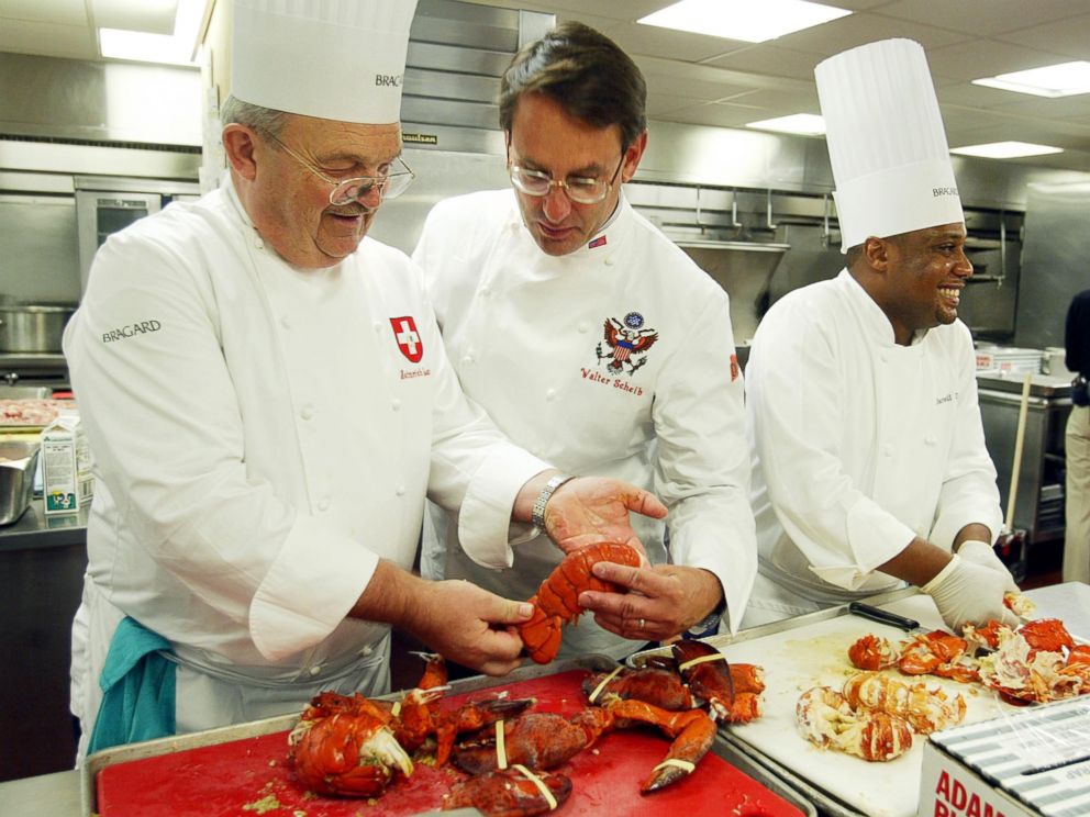 PHOTO: Heinrich Lauber, left, Chef in Charge of the Official Receptions of Switzerland, shows former White House Chef Walter Scheib, center, in this file photo, cooked lobsters, at the Willard InterContinental Washington,  July 26, 2004. 