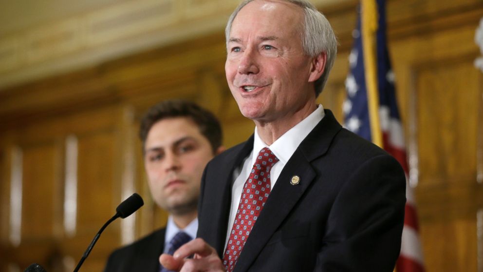Arkansas Gov. Asa Hutchinson answers reporters' questions as Sen. Jonathan Dismang, R-Beebe, background, listens at the state Capitol in Little Rock, Ark., April 1, 2015. 