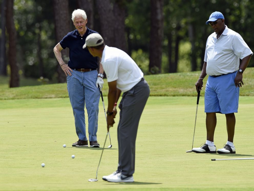 PHOTO: President Barack Obama, center, watches his putt as he plays golf with former President Bill Clinton, left, and Amb. Ron Kirk, right, former United States Trade Representative in Oak Bluffs, Mass., on Martha's Vineyard, Aug. 15, 2015. 