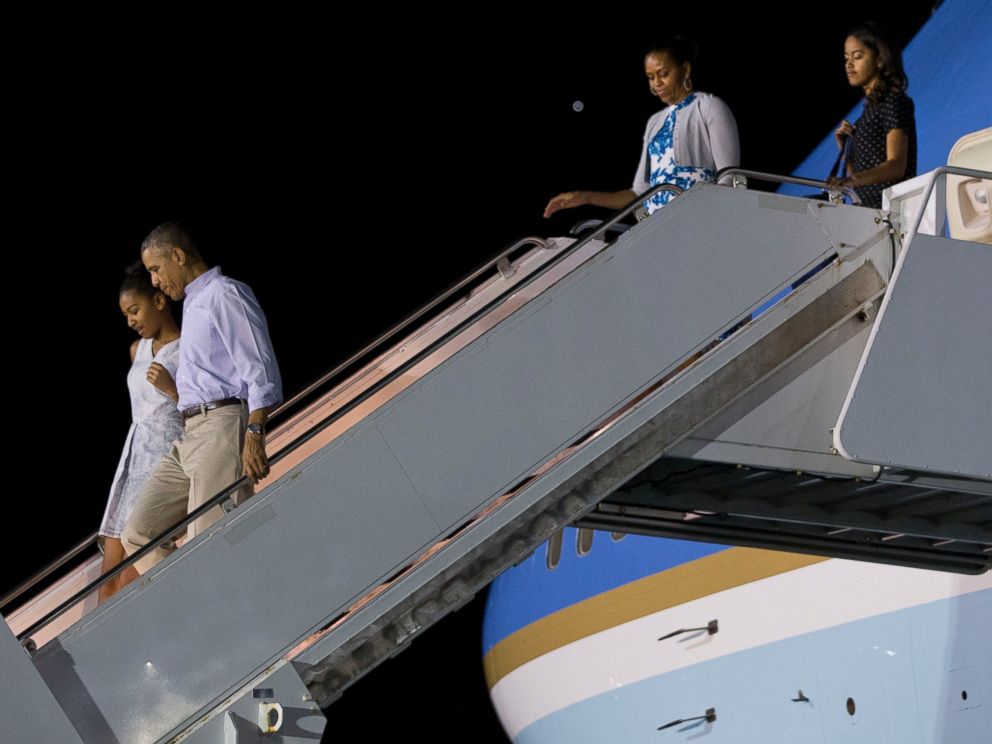 PHOTO: President Barack Obama walks with Sasha Obama as first lady Michelle Obama walks with Malia Obama, as the first family arrives at Pearl Harbor, Hawaii to begin their family vacation, Dec. 19, 2014.