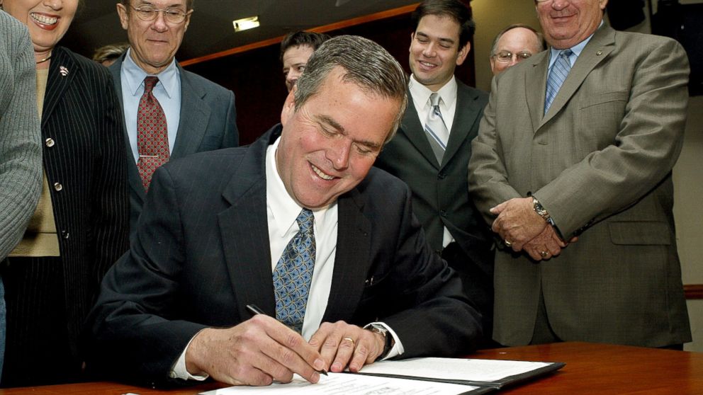 PHOTO: Jeb Bush, seated, signs into law the Kid Care bill on March 11, 2004 in Tallahassee, Fla.
