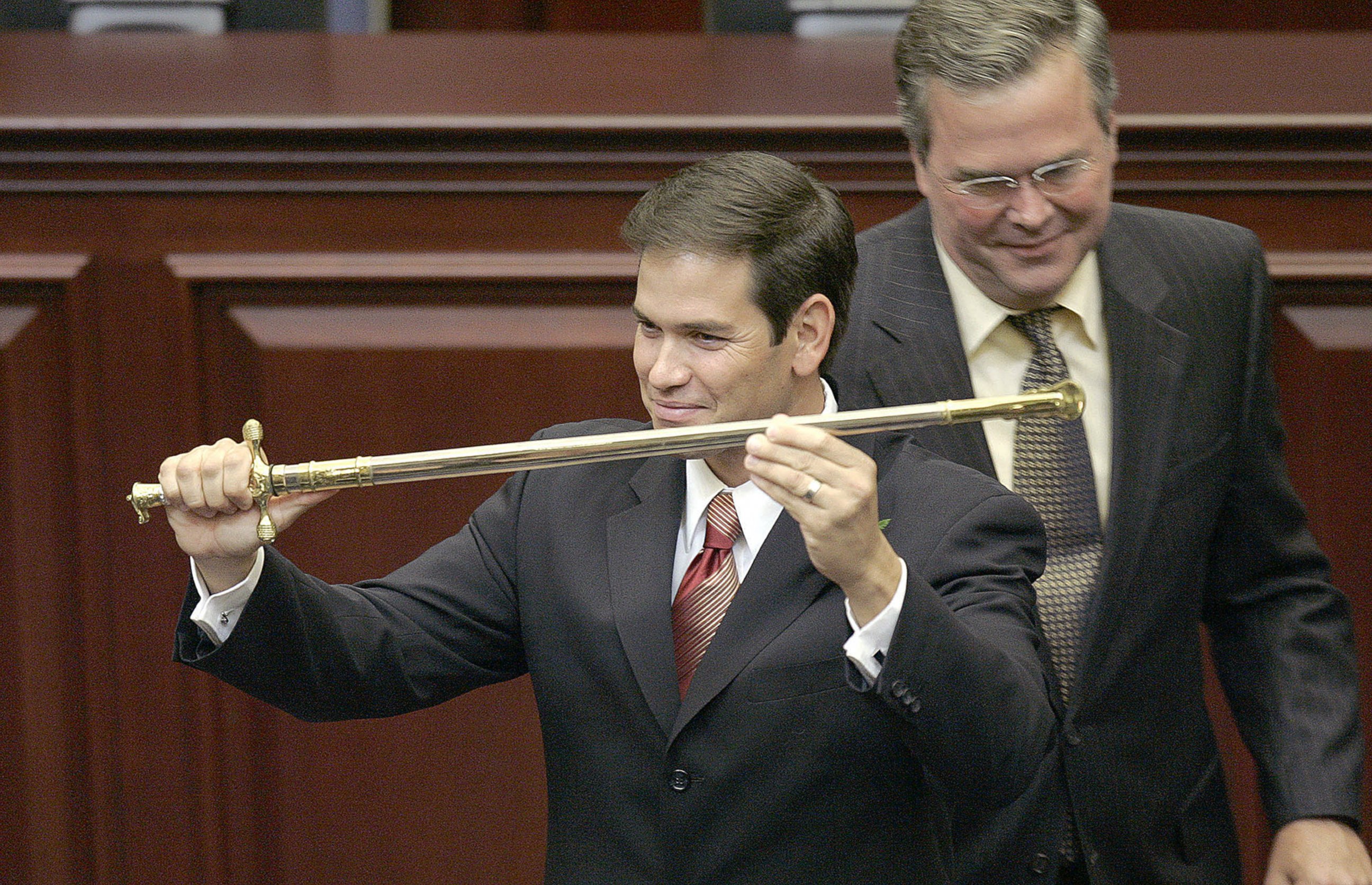 PHOTO: Marco Rubio, left, holds a sword presented to him by Jeb Bush, right, in Tallahassee, Fla. on Sept. 13, 2005.