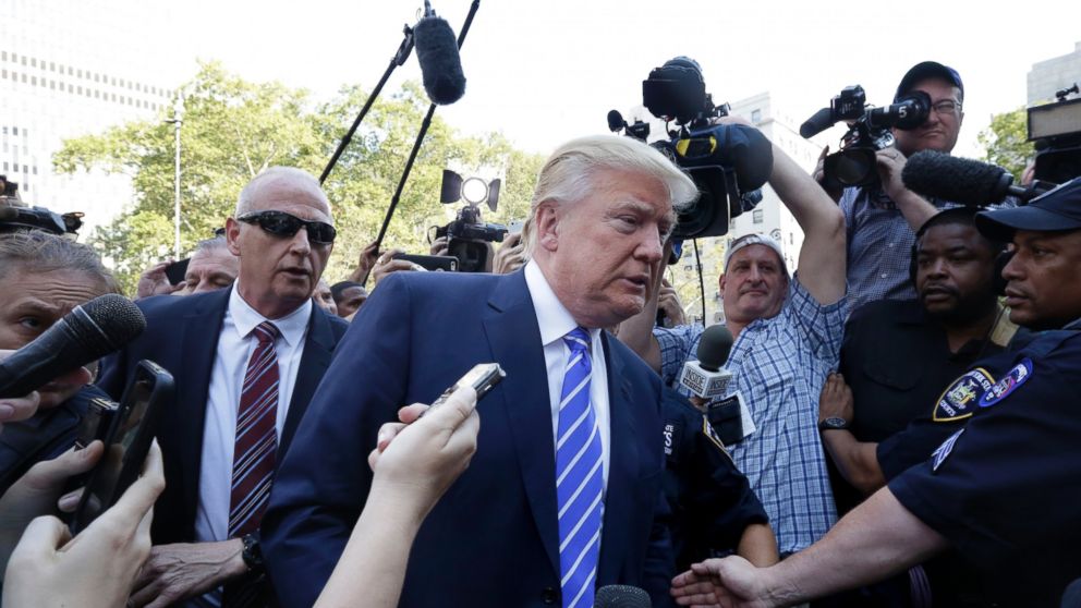 Republican presidential candidate Donald Trump is surrounded by media as he arrives for jury duty in New York, Aug. 17, 2015. 
