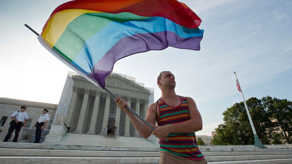 Gay rights advocate Vin Testa waves a rainbow flag in front of the Supreme Court in Washington, June 26, 2013. 