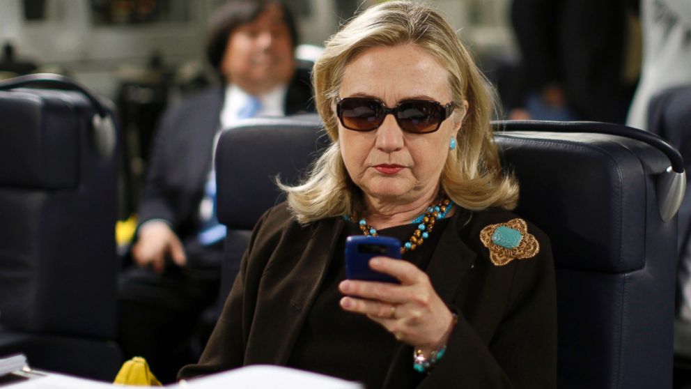 Secretary of State Hillary Rodham Clinton checks her Blackberry from a desk inside a C-17 military plane upon her departure from Malta, Oct. 18, 2011.
