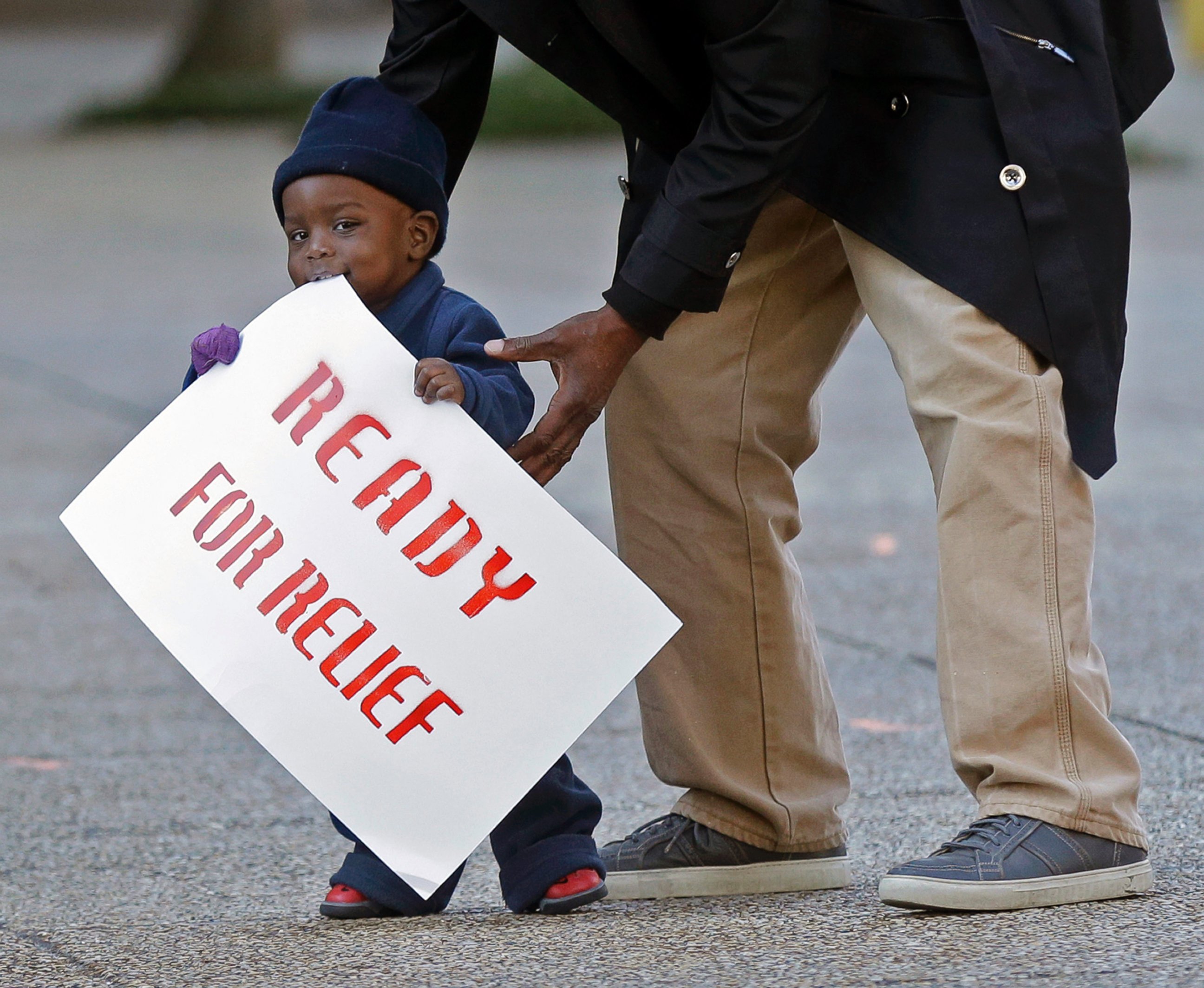 PHOTO: Lavon Massey, 1, holds a sign as immigrants and activists hold a protest outside the U.S. Citizenship & Immigration Service office in New Orleans, Nov. 19, 2014.
