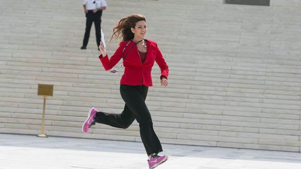 Members of the news media, including interns for network television stations, run with decisions in hand on the opinion for health care, June 25, 2015, in an official tradition referred to as the "running of the interns in Washington. 