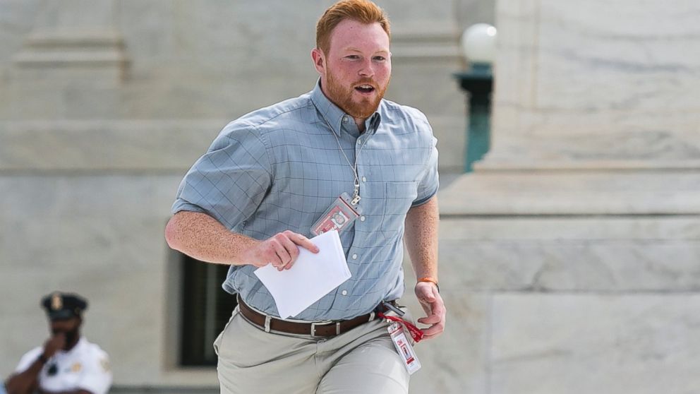 Members of the news media, including interns for network television stations, run with decisions in hand on the opinion for health care in Washington, June 25, 2015, in an official tradition referred to as the "running of the interns."