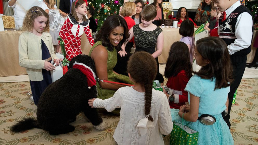 PHOTO: First lady Michelle Obama with dogs Bo, left, and Sunny, behind at right, are surrounded by children in the State Dining Room of the White House in Washington, Dec. 2, 2015.