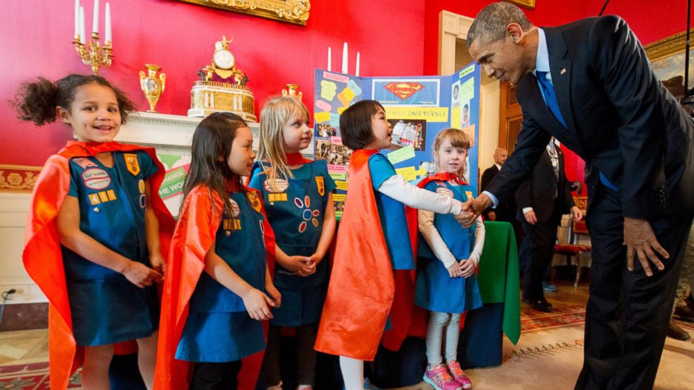 Dressed in super hero capes, six-year-old Girl Scouts, from left, Alicia Cutter, Addy O'Neal, Emery Dodson, Karissa Cheng, and Emily Bergenroth, of Tulsa, Oklahoma, meet with President Barack Obama before showing him their project during his tour of the White House Science Fair, March 23, 2015.