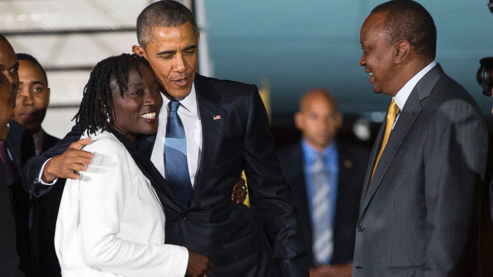 PHOTO: Kenyan President Uhuru Kenyatta, right, watches as President Barack Obama, center, hugs his half-sister Auma Obama, left, after he arrived at Kenyatta International Airport on July 24, 2015 in Nairobi, Kenya. 