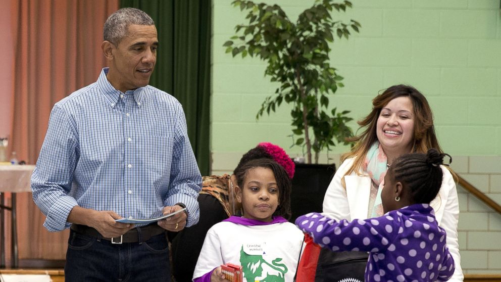 President Barack Obama hands out books as he participates in a service project at Leckie Elementary School in Washington, Jan. 18, 2016, to commemorate Martin Luther King, Jr. Day of Service.