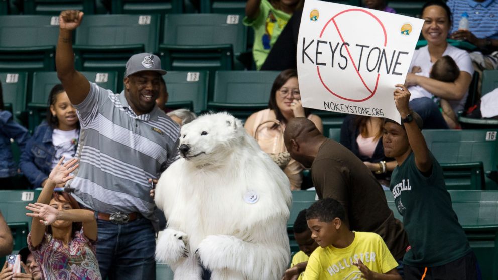 A person dressed as a polar bear and others demonstrate against the Keystone Pipeline as President Barack Obama and the first family attend the Oregon State University versus University of Akron college basketball game at the Diamond Head Classic at the Stan Sheriff Center in Honolulu, Dec. 22, 2013.