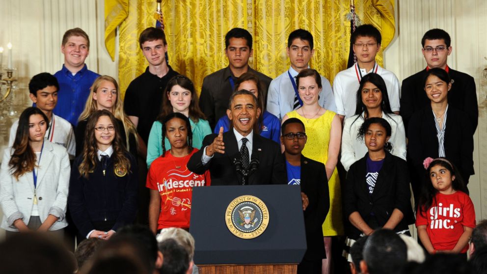 President Barack Obama speaks with some of the 2014 White House Science Fair kids behind him, May 27, 2014, in the East Room of the White House in Washington.