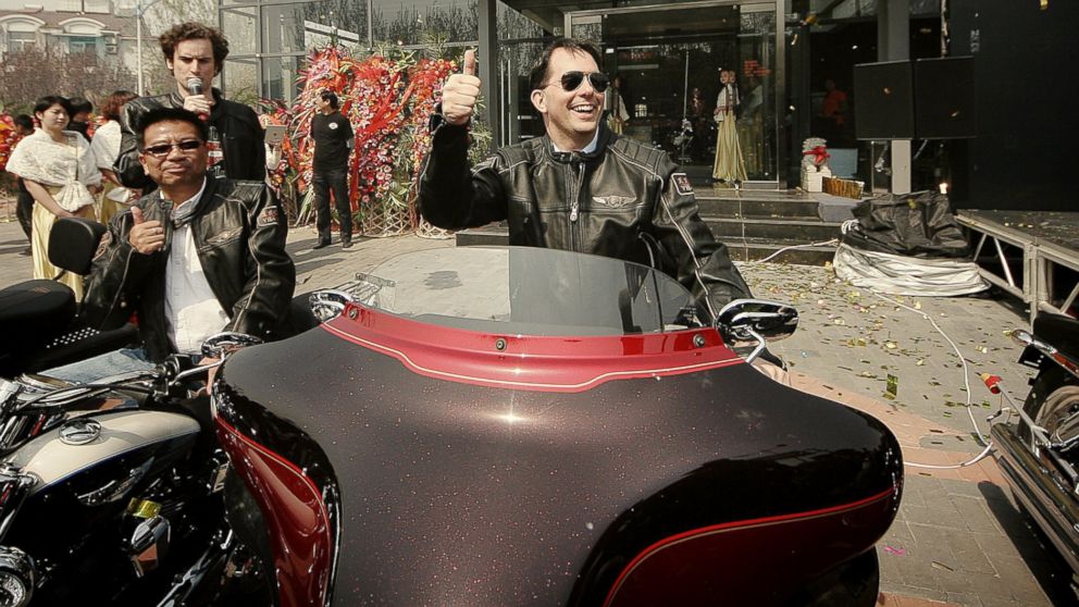 Wisconsin Governor Scott Walker, center, shows a thumb-up on a Harley-Davidson motorcycle during the opening ceremony of the Harley-Davidson dealership in Tianjin, China, April 16, 2013.