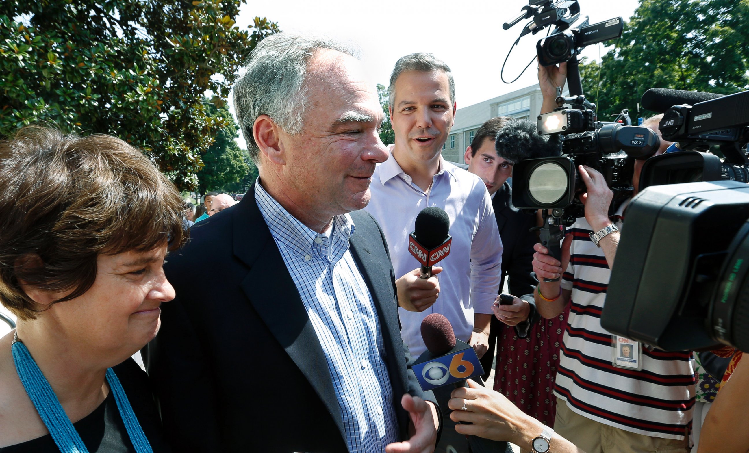 PHOTO: Senator Tim Kaine, center, with his wife Anne Holton, answers questions after attending Mass at their church, St. Elizabeth Catholic Church, in Richmond, Va., July 24, 2016.