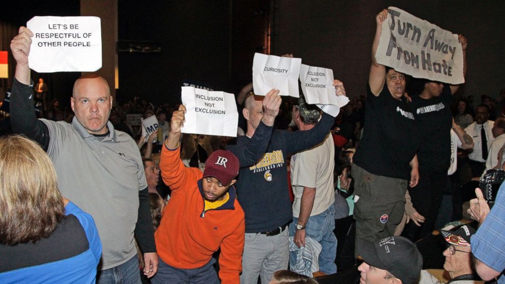 Protesters hold up signs as Republican presidential candidate Donald Trump speaks at a rally at Lenoir-Rhyne University in Hickory, N.C., March 14, 2016.