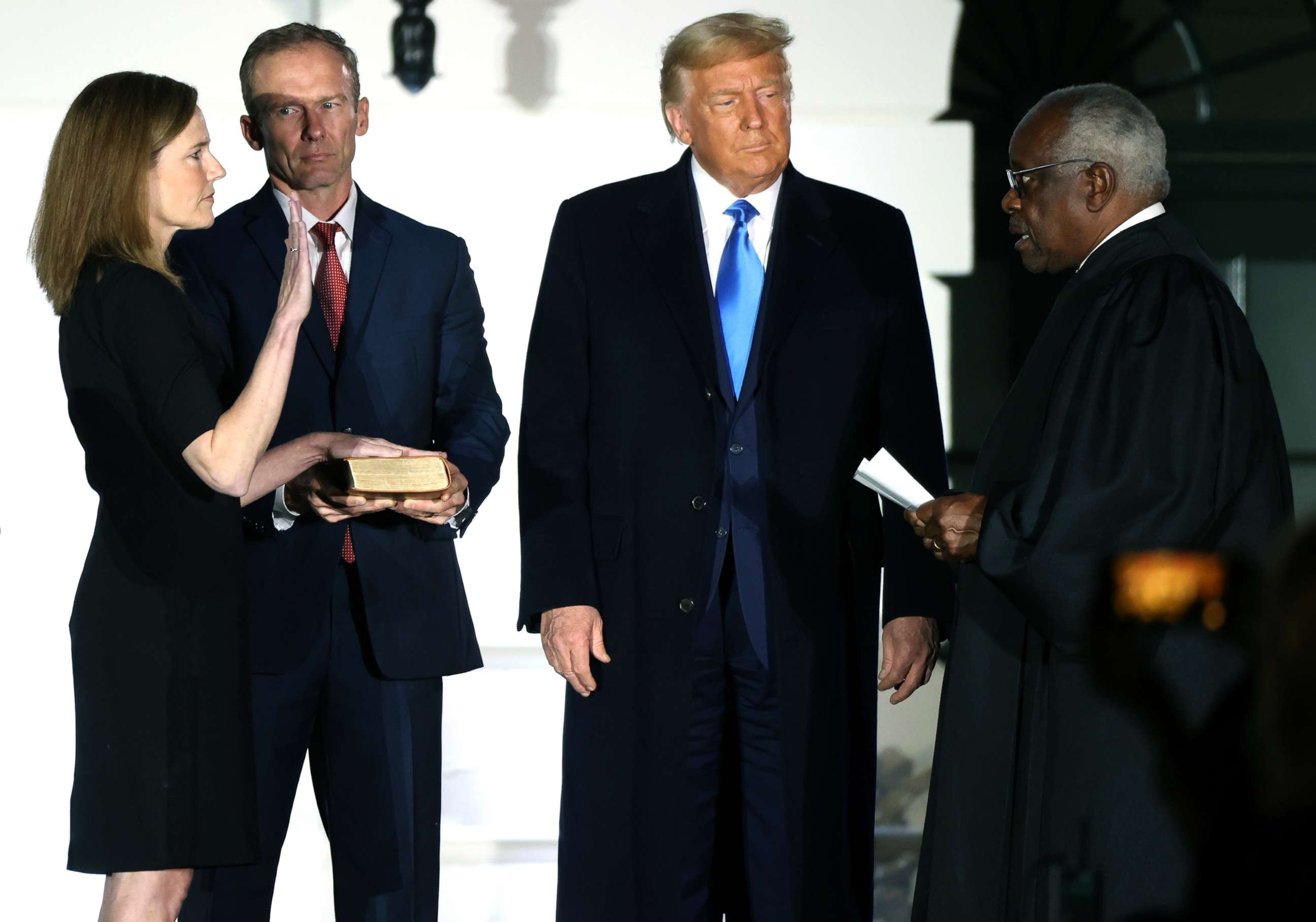 PHOTO: Judge Amy Coney Barrett is sworn in to serve as an associate justice of the Supreme Court by Supreme Court Justice Clarence Thomas as her husband Jesse Barrett and President Donald Trump watch on the South Lawn of the White House, Oct. 26, 2020.   