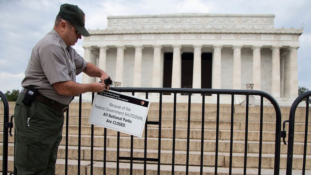 A National Park Service employee posts a sign on a barricade to close access to the Lincoln Memorial in Washington, Oct. 1, 2013. 