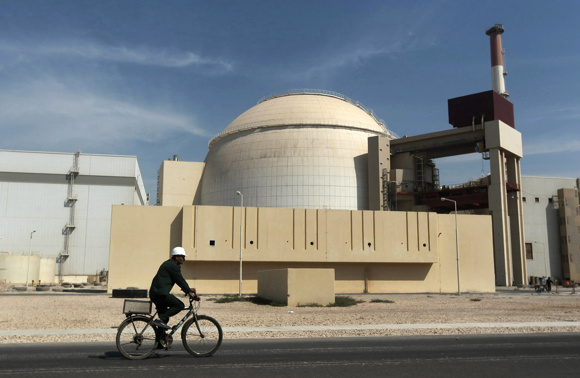 PHOTO: A worker rides a bicycle in front of the reactor building of the Bushehr nuclear power plant, just outside the southern city of Bushehr, Iran, Oct. 26, 2010. 