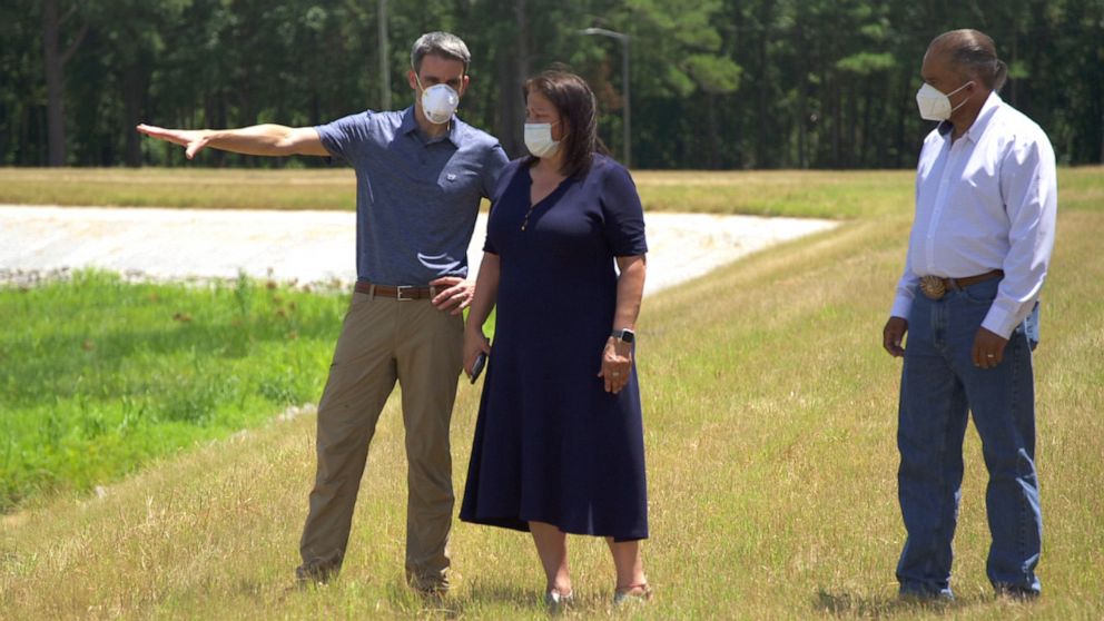 PHOTO: ABC News' Devin Dwyer walks with Lumbee tribal administrator Freda Porter and chairman Harvey Godwin along a newly repaired dam on a sacred lake at the tribe's cultural center in Pembroke, N.C.