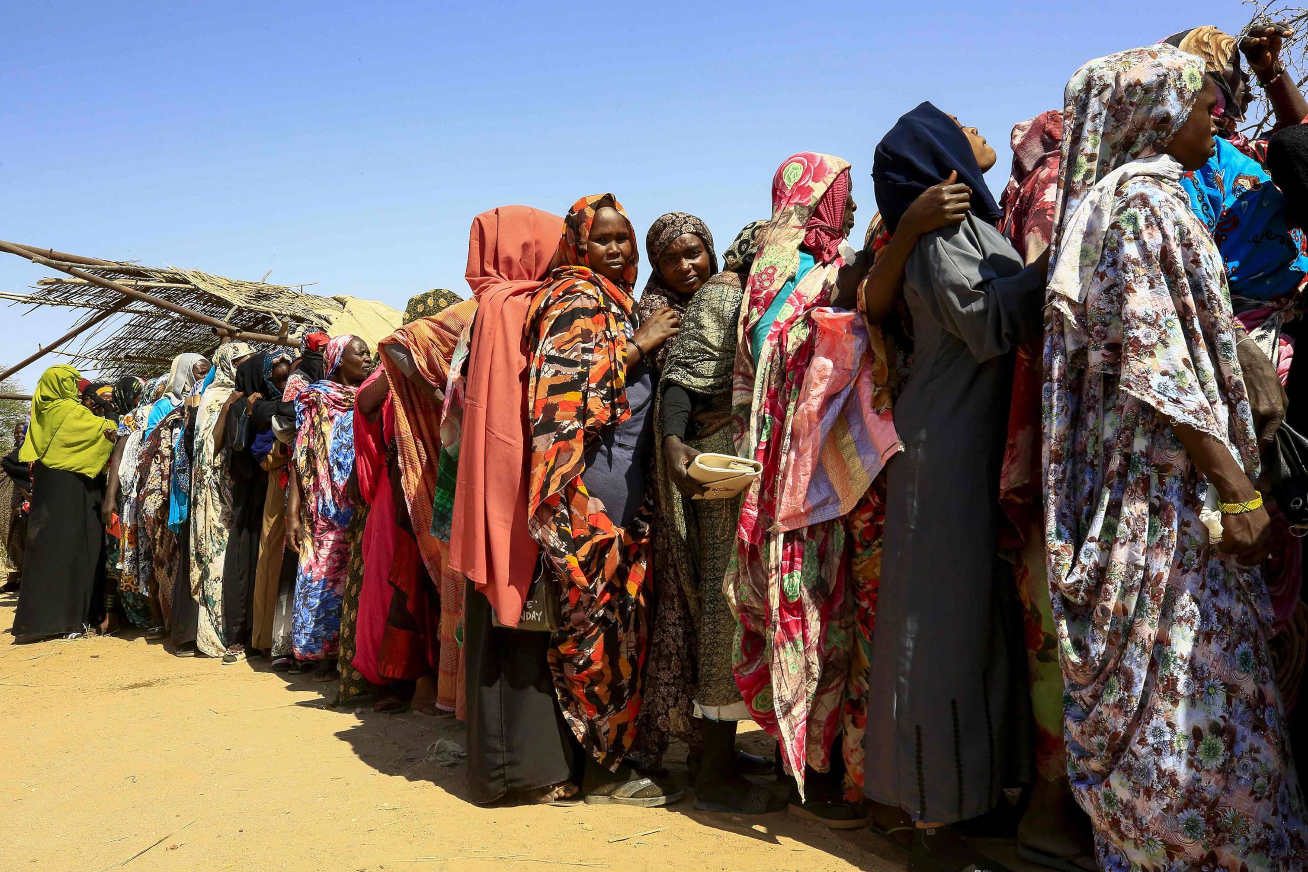 PHOTO: Displaced Sudanese women wait for the arrival of the World Food Programme (WFP) aid in the Otash internally displaced people's camp on the outskirts of Nyala town, the capital of South Darfur, Feb. 1, 2021. 