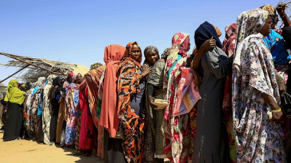 PHOTO: Displaced Sudanese women wait for the arrival of the World Food Programme (WFP) aid in the Otash internally displaced people's camp on the outskirts of Nyala town, the capital of South Darfur, Feb. 1, 2021. 