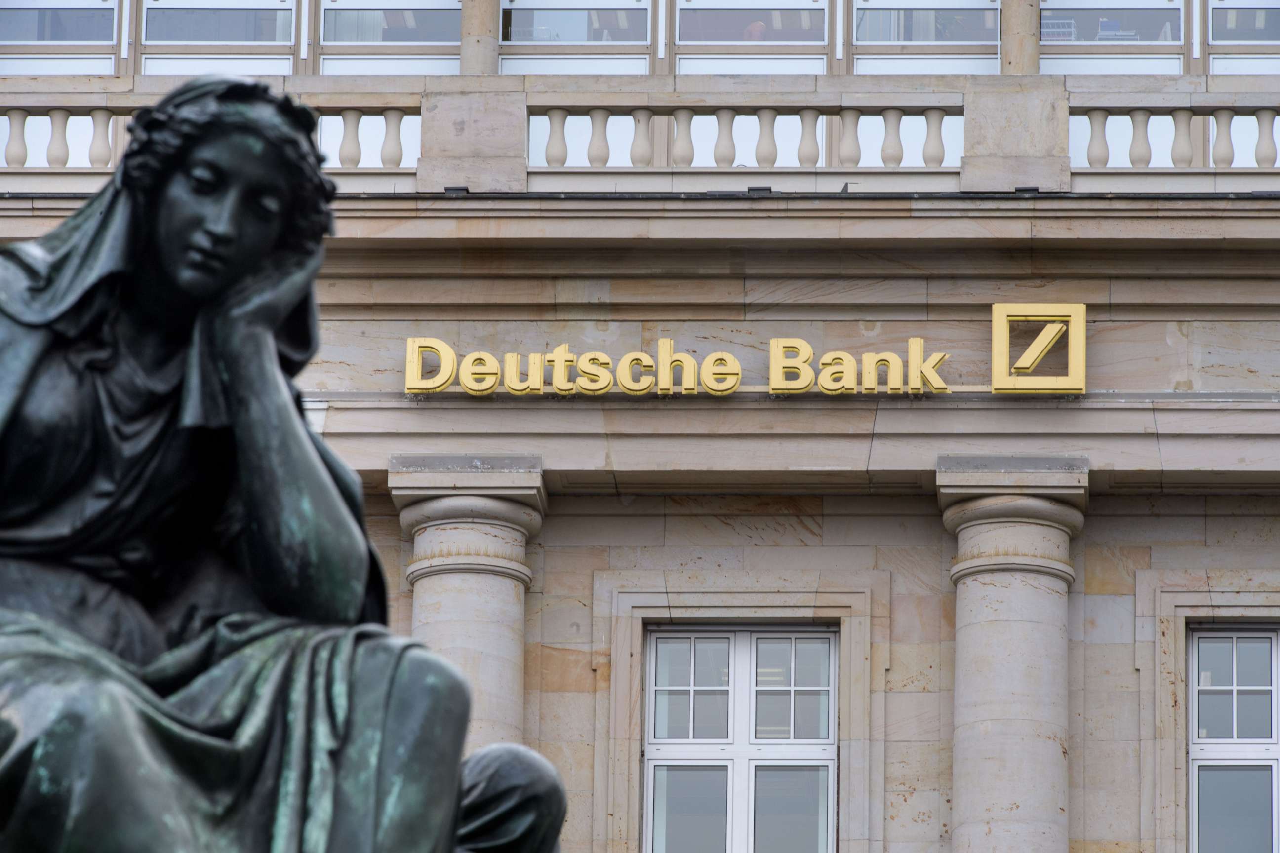 PHOTO: A branch of the German bank Deutsche Bank pictured with a sculpture of the 'Gutenberg' monument, Feb. 1, 2018, in Frankfurt, Germany.