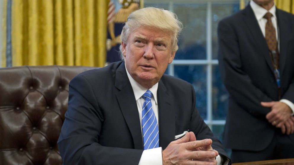 President Donald Trump prepares to sign three Executive Orders in the Oval Office of the White House in Washington, Jan. 23, 2017.