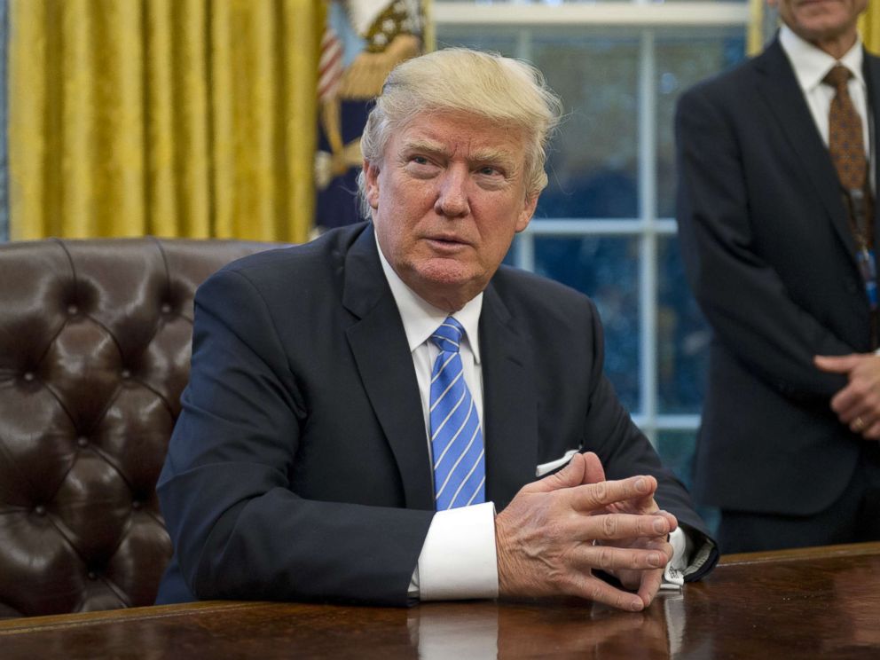 PHOTO: President Donald Trump prepares to sign three Executive Orders in the Oval Office of the White House in Washington, Jan. 23, 2017.