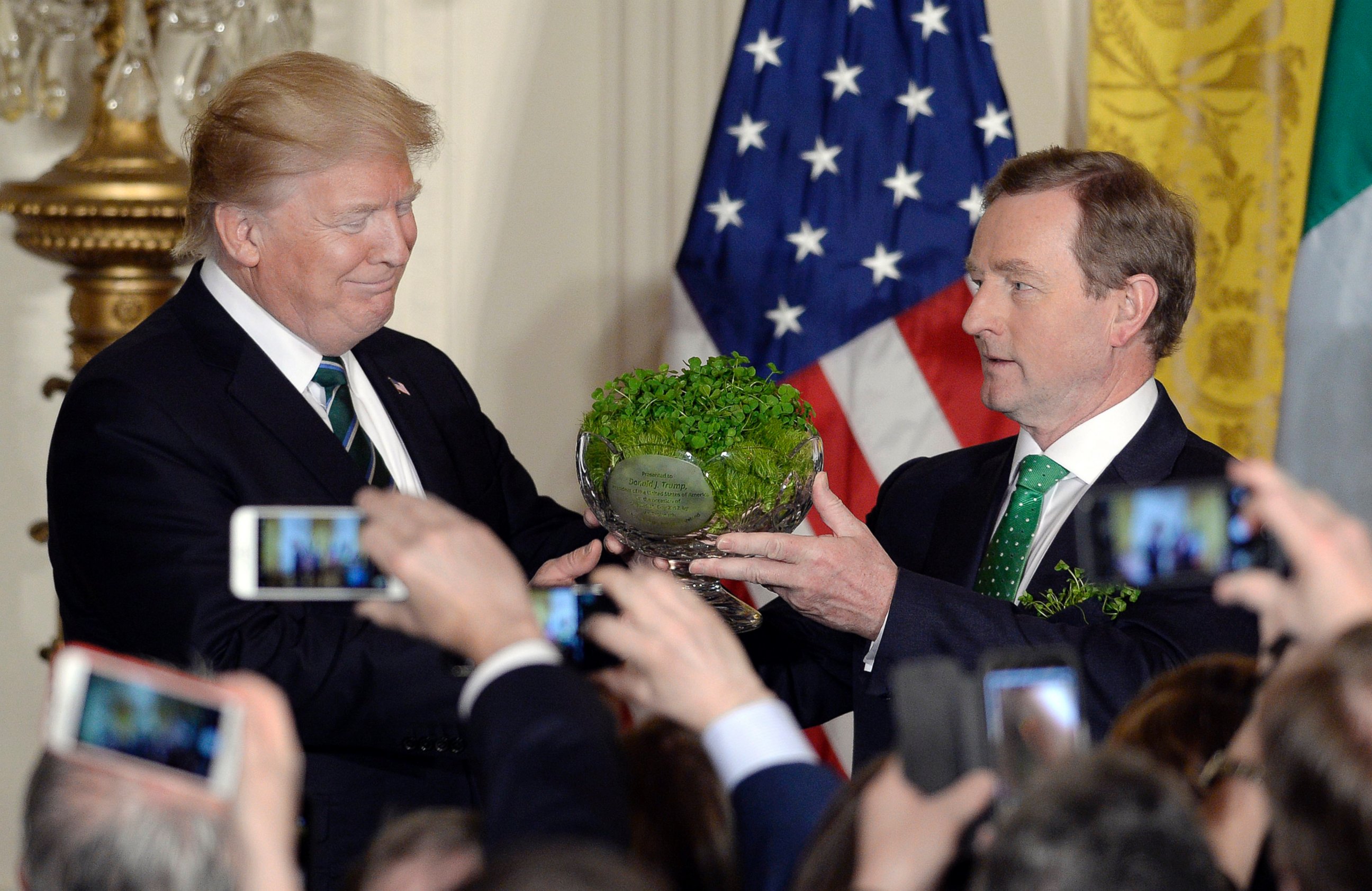 PHOTO: President Donald Trump, accepts a bowl of shamrocks from Enda Kenny, Ireland's prime minister during a reception in the East Room of the White House in Washington, March 16, 2017. 