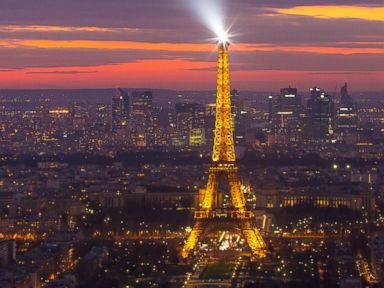 PHOTO: The Eiffel tower shining its spotlight just after sunset, March 16, 2014, in Paris.