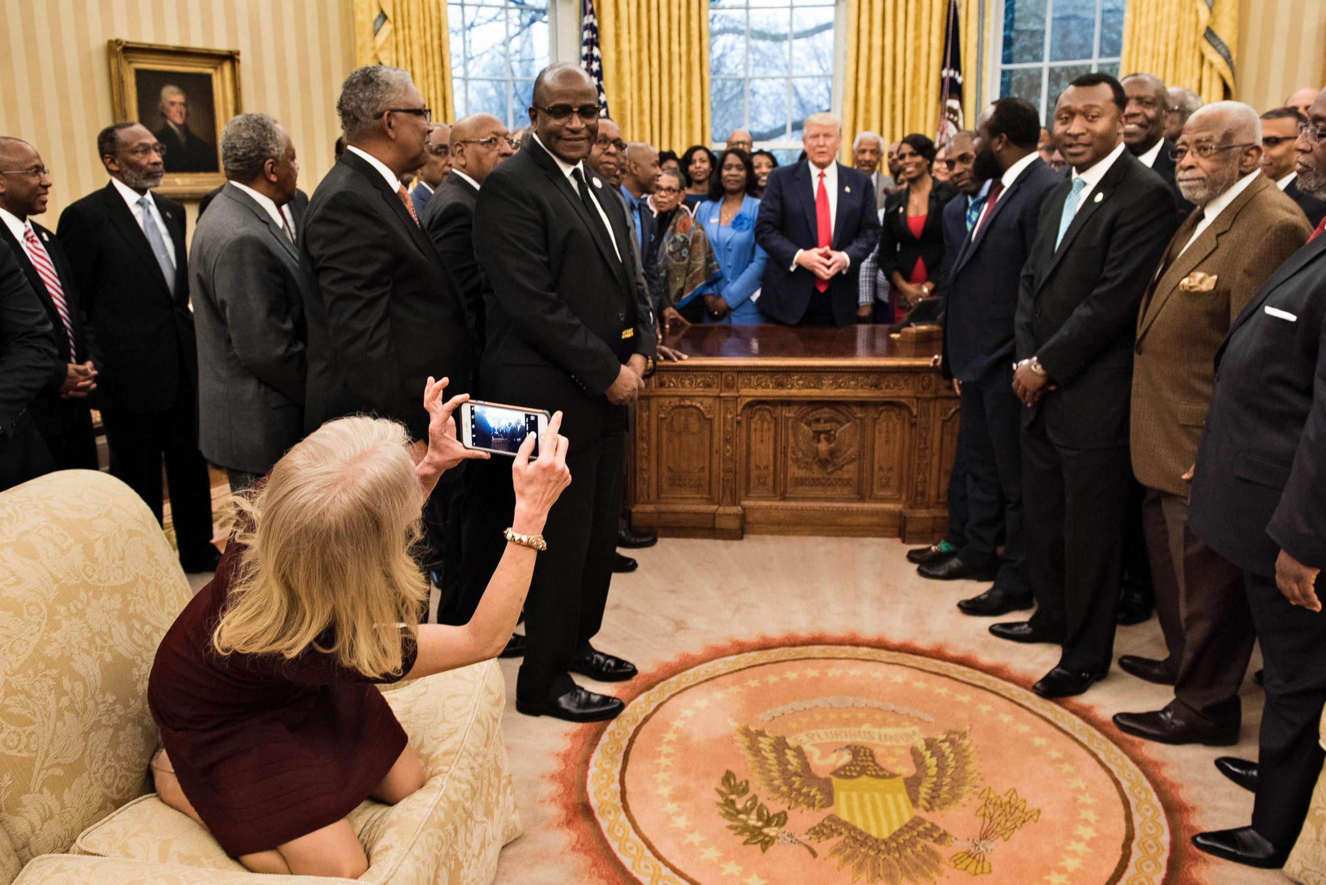 PHOTO: Counselor to the President, Kellyanne Conway, takes a photo as U.S. President Donald Trump and leaders of historically black universities and colleges talk before a group photo in the Oval Office of the White House, Feb. 27, 2017, in Washington.