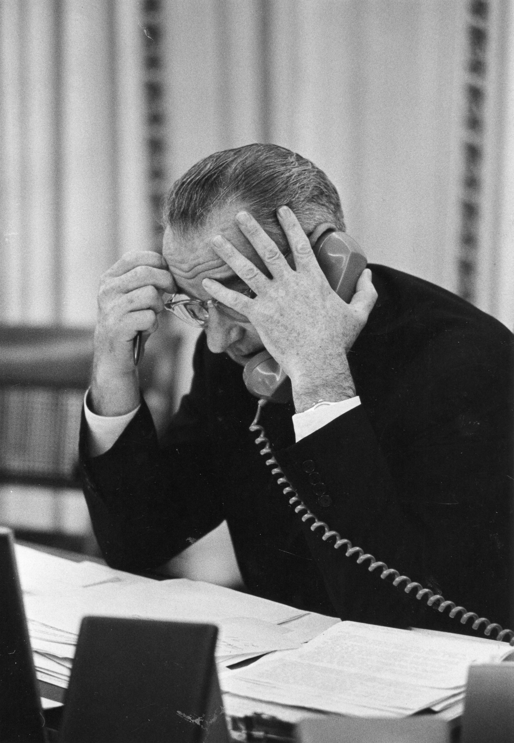 PHOTO: President Lyndon Johnson talks on the telephone at his desk in the White House Oval Office, Jan. 1, 1964. 