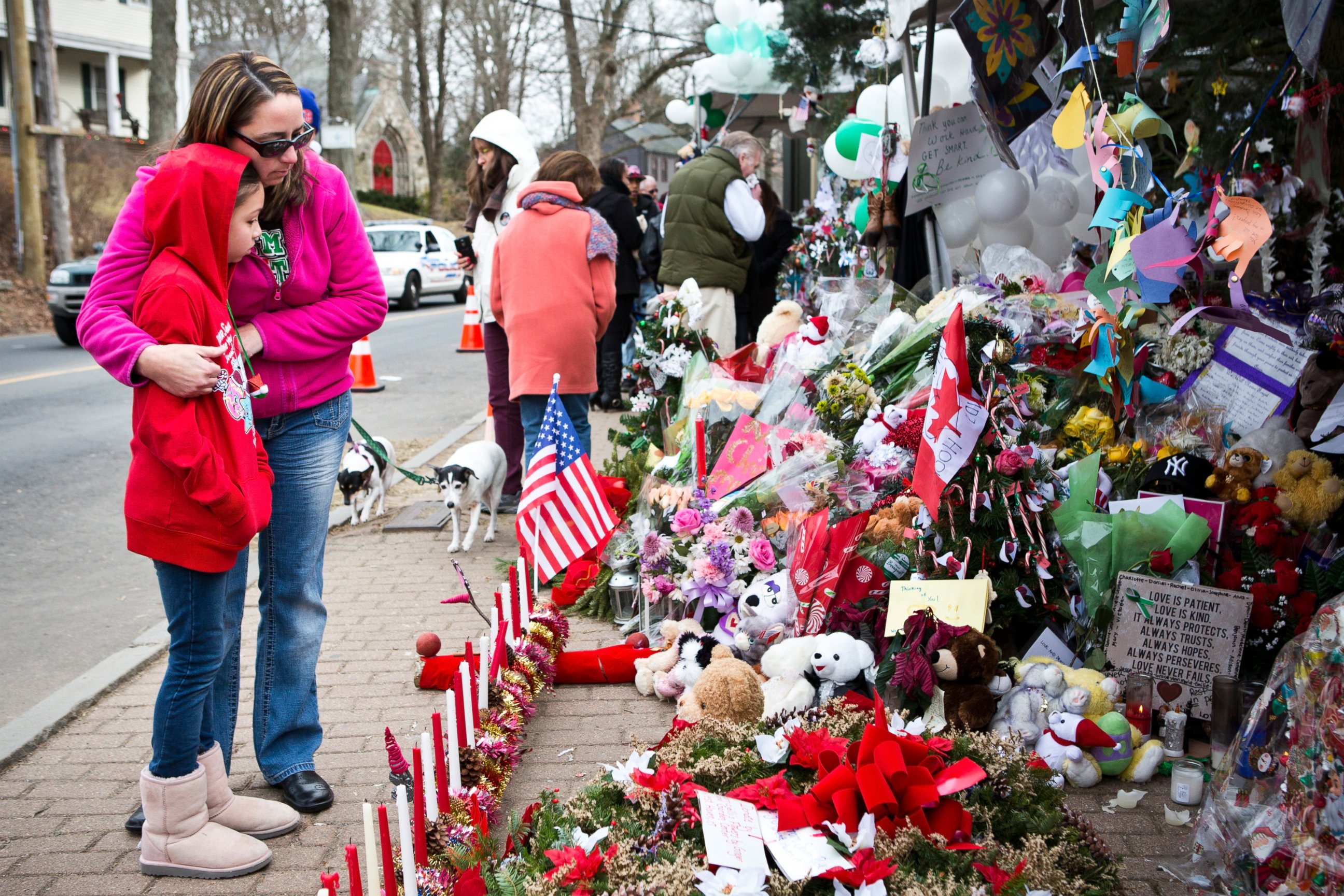 PHOTO: Deborah Gibelli holds her daughter, Alexandra Gibelli, age 9, while looking at a memorial for those killed in the school shooting at Sandy Hook Elementary School, on Dec. 24, 2012 in Newtown, Connecticut. 