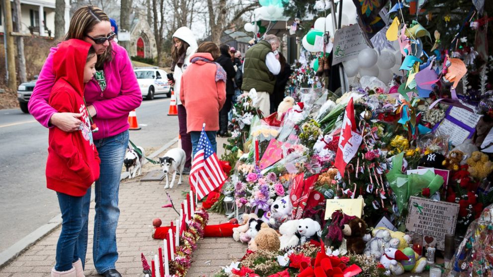 PHOTO: Deborah Gibelli holds her daughter, Alexandra Gibelli, age 9, while looking at a memorial for those killed in the school shooting at Sandy Hook Elementary School, on Dec. 24, 2012 in Newtown, Connecticut. 