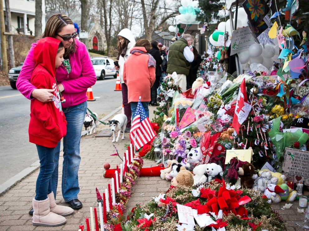 PHOTO: Deborah Gibelli holds her daughter, Alexandra Gibelli, age 9, while looking at a memorial for those killed in the school shooting at Sandy Hook Elementary School, on Dec. 24, 2012 in Newtown, Connecticut.