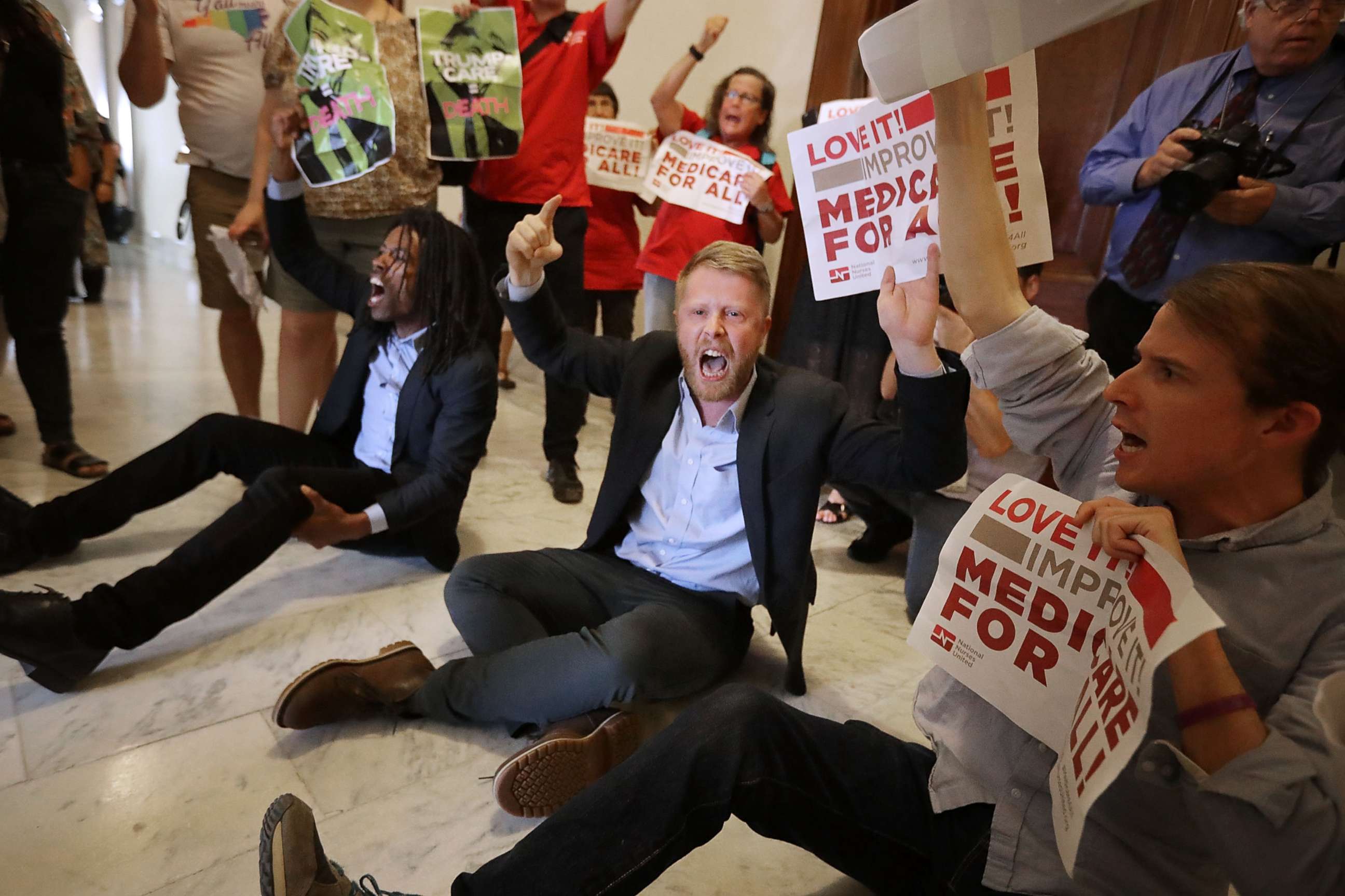 PHOTO: Demonstrators sit on the ground and chant outside the offices of Republican Sen. Ted Cruz while protesting against health care reform legislation in the Russell Senate Office Building on Capitol Hill on July 10, 2017, Washington. 