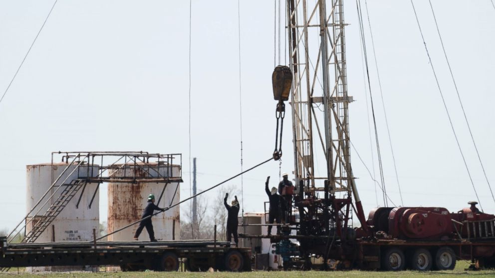 PHOTO: Oil field workers pull pipes from a fracking well, March 31, 2016, near, Crescent, Oklahoma. 