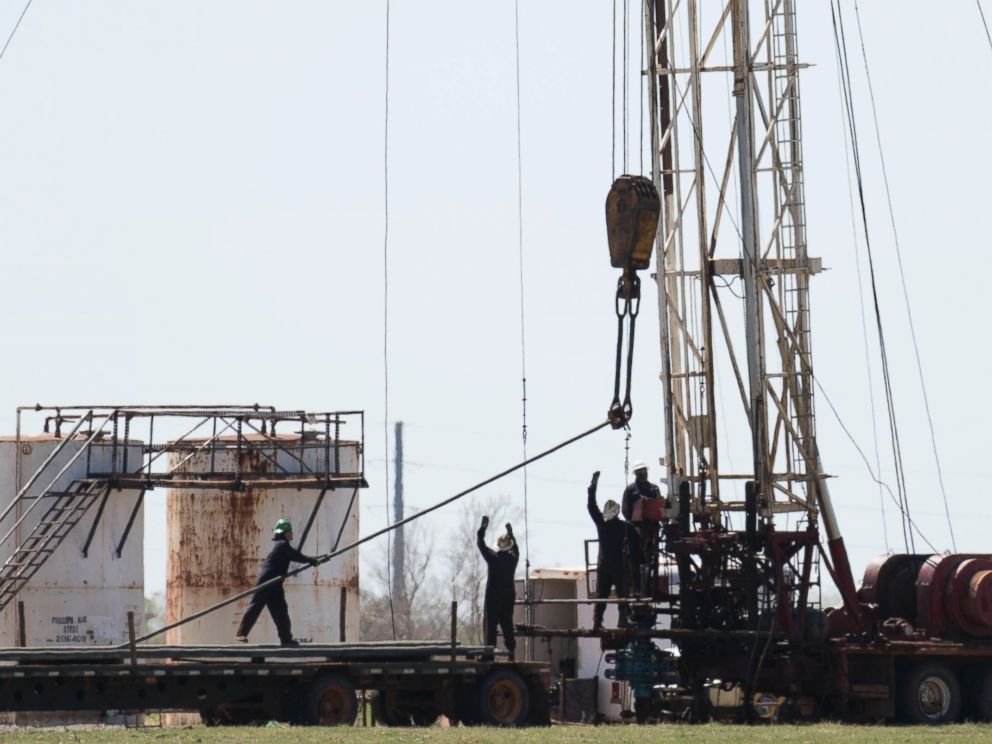 PHOTO: Oil field workers pull pipes from a fracking well, March 31, 2016, near, Crescent, Oklahoma.