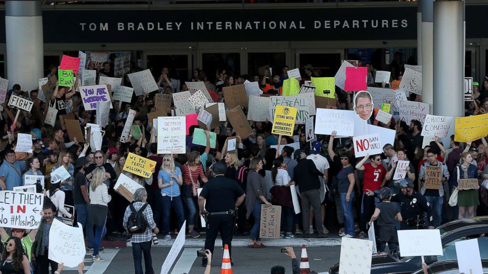 Protesters hold signs during a demonstration against the immigration ban at Los Angeles International Airport, Jan. 29, 2017.